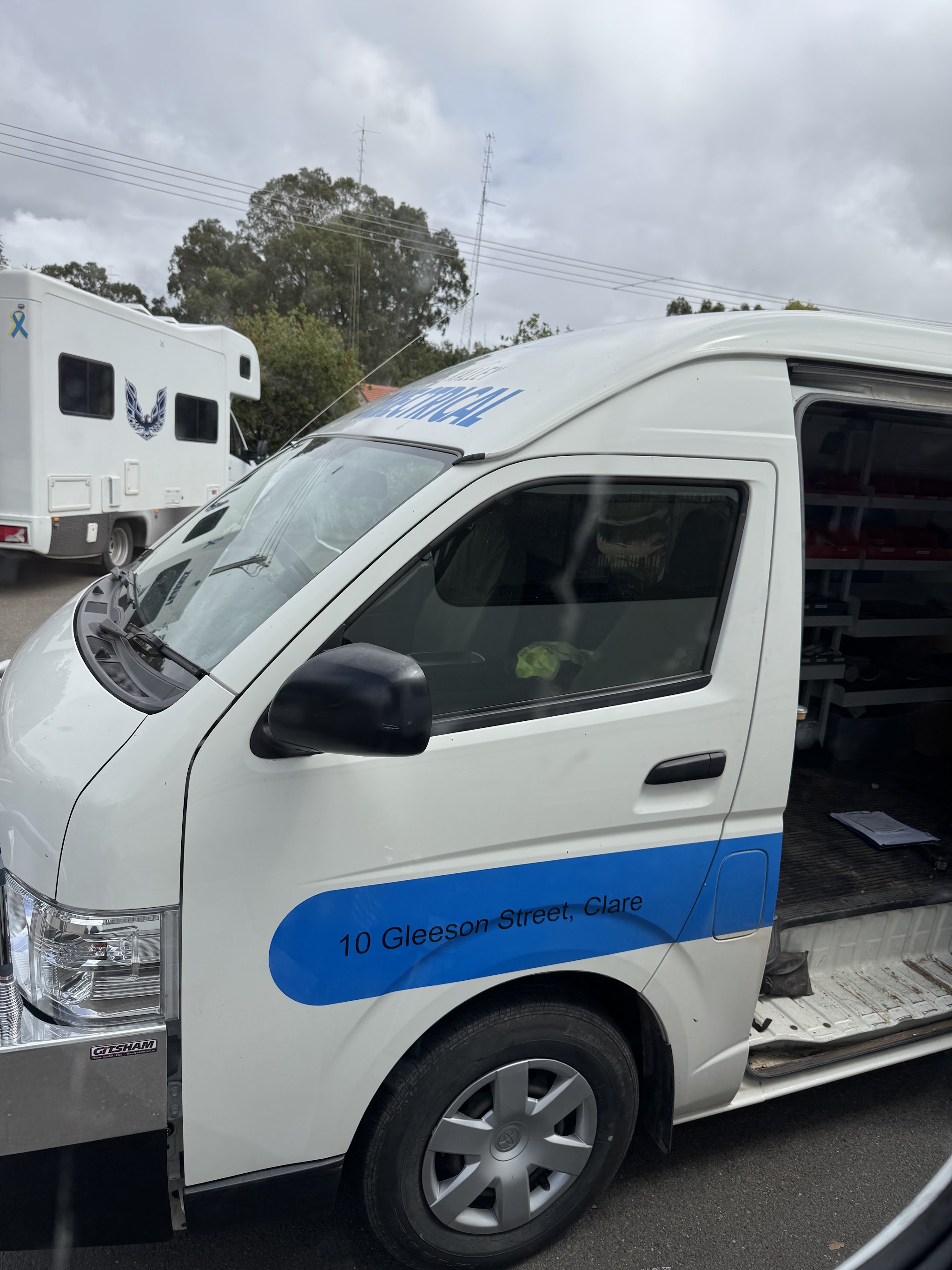A Clare Valley Auto Electrical service van, signwritten with the Gleeson Street address, parked beside a customer's motorhome
